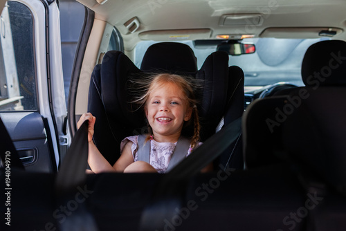 Happy kid seated in car buckled into extended rear facing ERF seat