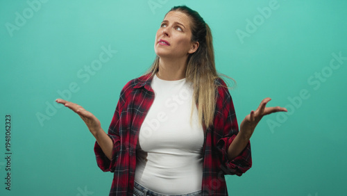 Foto Woman in red plaid shirt raises palms in a shrugging gesture with expressive face in studio; exasperation doubt