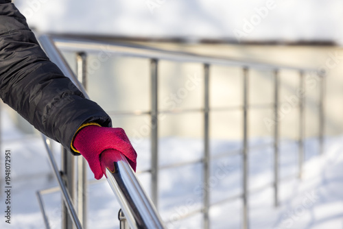 Billede på lærred A woman descends the stairs holding onto the railing in winter