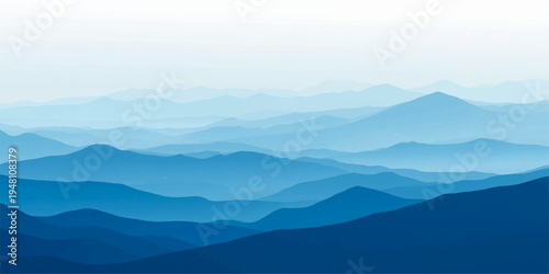 Misty blue mountain range at dawn with a forest valley under a soft morning sky and hazy clouds.