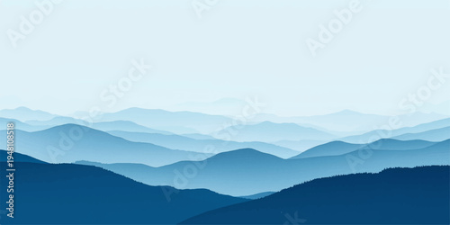 A misty sunrise reveals a breathtaking mountain landscape where forest hills and deep valleys sit under a blue sky filled with clouds at the dawn horizon.