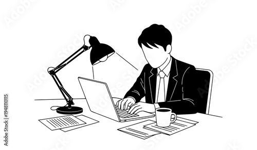 A businessman working on his laptop at a desk with a lamp and coffee