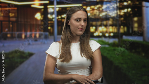 Woman holding makeup brush with arms crossed in front of building entrance at night; poise confidence. Free Download Woman holding makeup brush with arms crossed in front of building entrance at night; poise confidence. - GFXLoad
