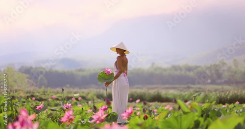 Woman Walking Through Lotus Field At Sunrise, Vietnam, Cinematic Wide Shot