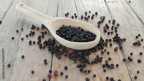 Obraz na plátně Black pepper and peppercorn on wooden board.