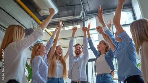 Diverse team celebrating success with raised hands in modern office