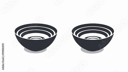 Two black bowls with concentric white rings, casting soft shadows on white backdrop