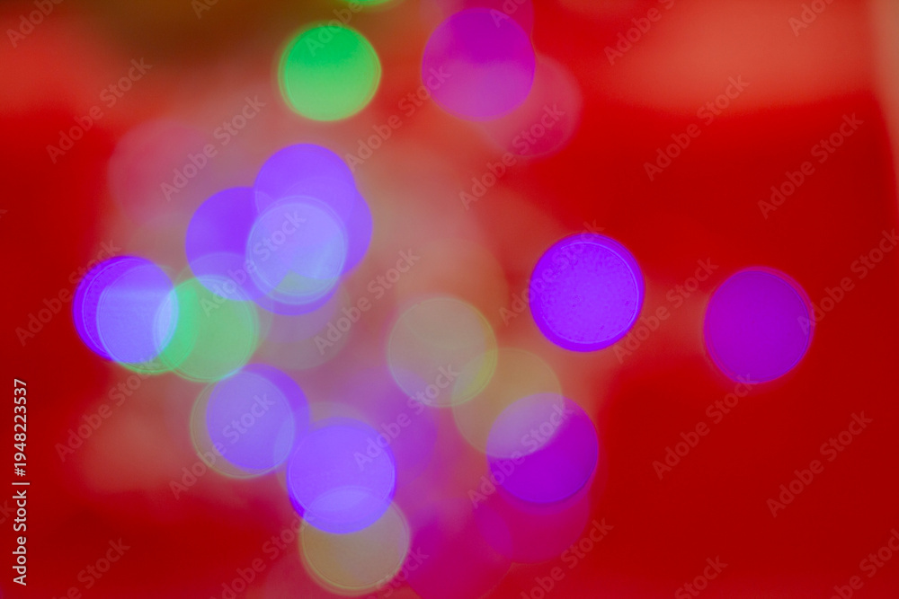 Obraz premium Abstract colorful bokeh lights with soft blurred circles on a vibrant red background, creating a festive and artistic visual effect.
