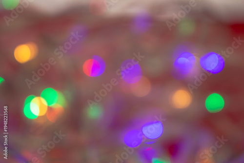Abstract multicolored bokeh light circles softly blurred over a warm neutral background, creating a dreamy and decorative atmosphere.