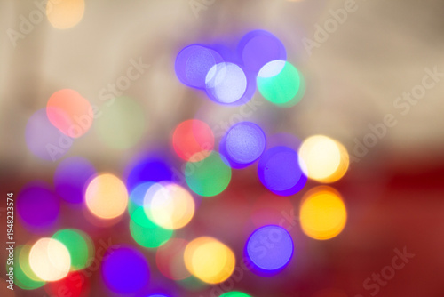 Abstract colorful bokeh light circles softly blurred on a warm background, creating a dreamy and festive visual effect.