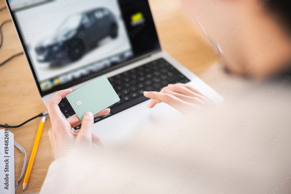 © Studio Marmellata - A person uses a credit card to make an online purchase of a vehicle displayed on a laptop screen. © Studio Marmellata - A person uses a credit card to make an online purchase of a vehicle displayed on a laptop screen.