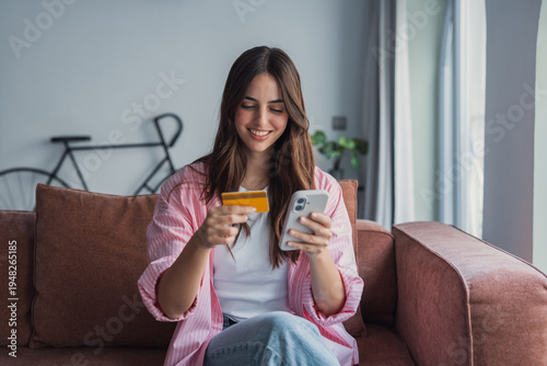 Safe mobile banking. Smiling latina lady client hold mobile phone credit bank card do online shopping provide internet payment. Happy young woman enjoy easy fast secure transferring money in ebank app