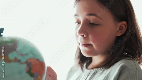 Little girl looking at globe and dreaming of travel, 4K 10-bit.	
