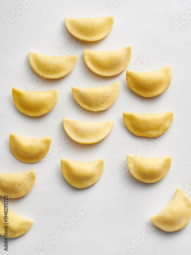 The image shows freshly made pasta dough shaped in uniform half-moons. Ideal for food blogs, restaurant menus, and culinary magazines focusing on Italian cuisine
