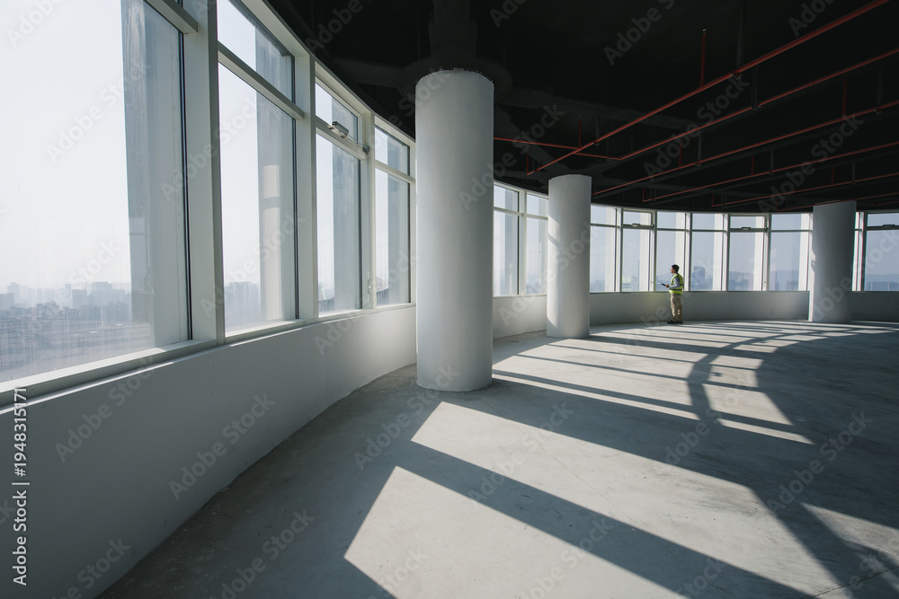 Obraz premium Spacious office interior with abundant natural light and structural columns in an unfinished high-rise building