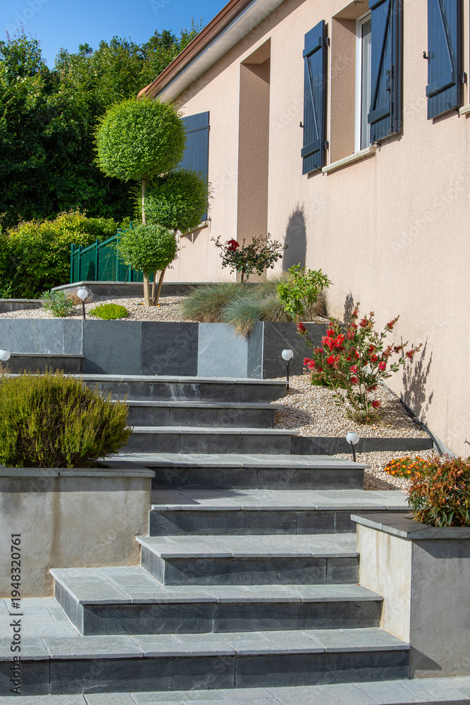 Fototapeta premium Jardin paysagé au pied du jolie maison au printemps.