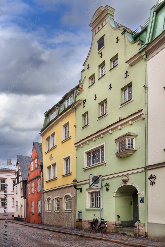 Fototapeta premium Historic street with colorful houses in Old Town of Riga, Latvia. Beautiful green facade and traditional medieval architecture