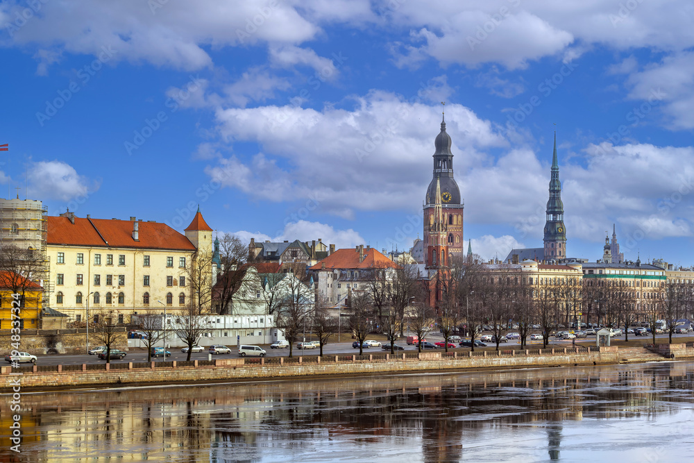 Fototapeta premium Daylight panoramic view of Old Riga city skyline from Daugava river, Latvia. Historic church spires and medieval buildings