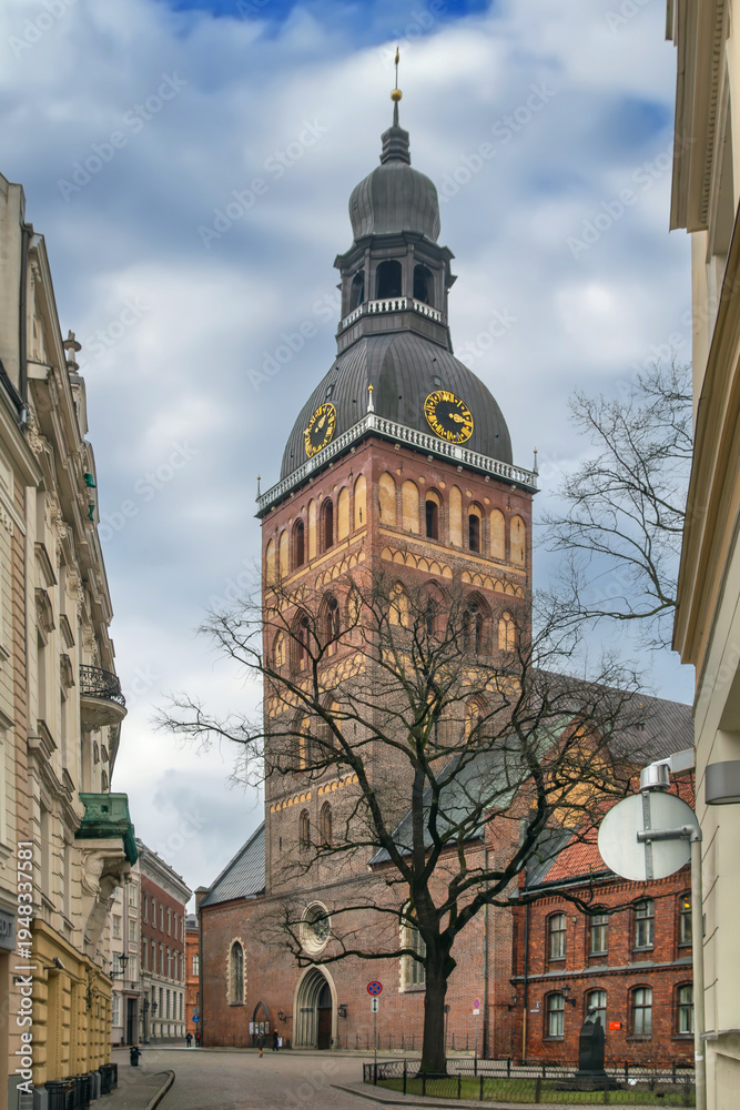 Fototapeta premium View of Riga Cathedral tower and small square on a cloudy February day, Latvia. Historic Lutheran cathedral and city street