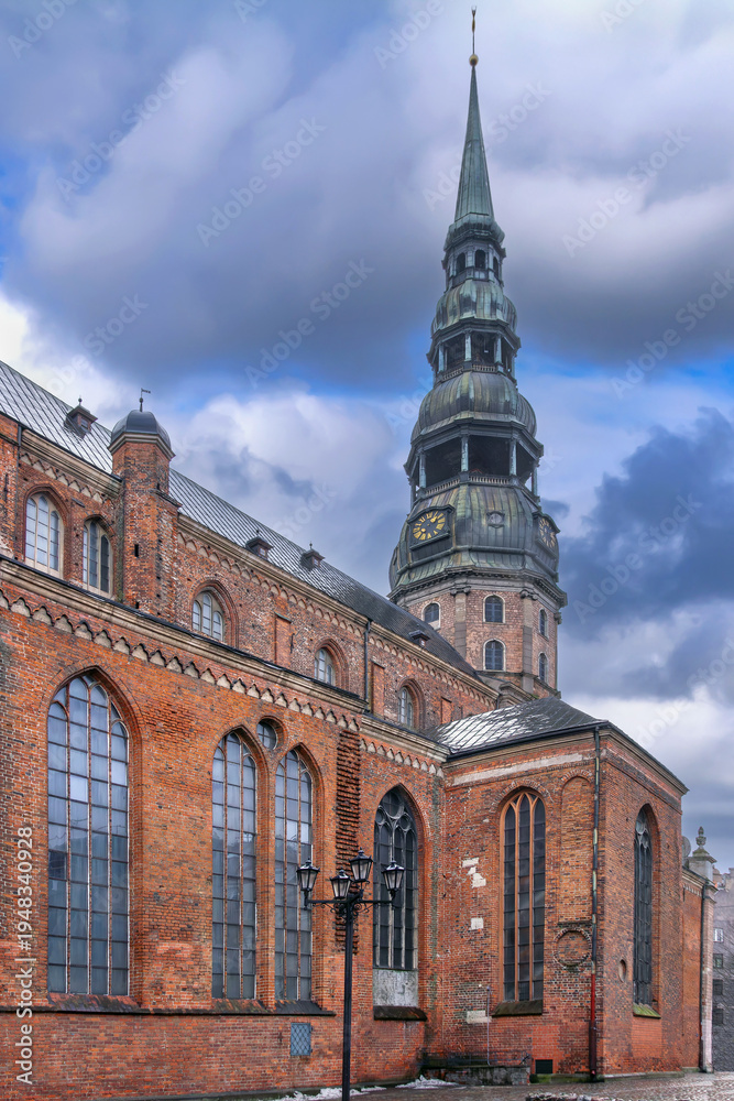Obraz premium Side and rear view of St Peters Church in Old Town, Riga, Latvia. Historic Gothic architecture and red brick walls