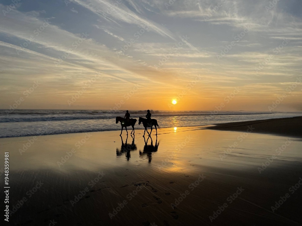 Fototapeta premium Couple Riding Horses on Bali Beach at Sunset