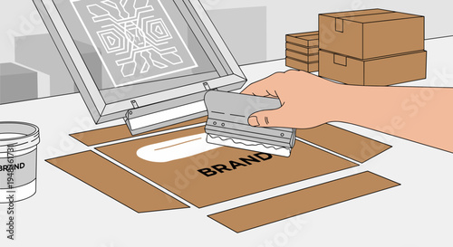 A hand screen prints the word BRAND onto a brown cardboard box.