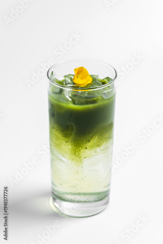 Refreshing iced matcha tonic drink in a transparent collins highball glass on white background with copy space
