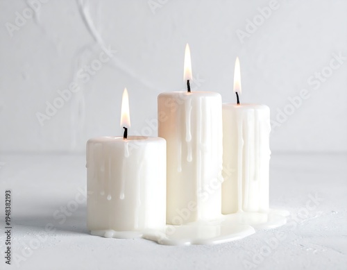 Three white candles burning, wax melting down sides, simple white background