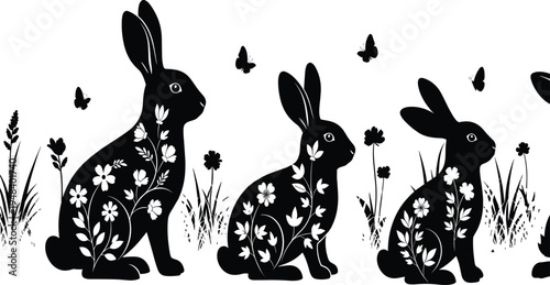 Black rabbits with white floral patterns sitting among flowers and butterflies
