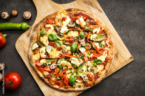 Titel: Homemade pizza with mozzarella, vegetables and hollandaise sauce on wooden pizza peel