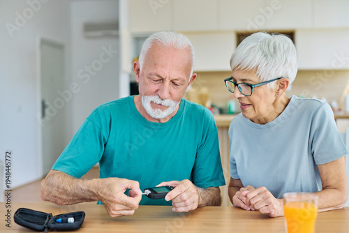 Фотография Portrait of senior couple using lancet on finger for checking blood sugar level with glucose meter
