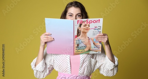 Woman with lifestyle magazine on olive background