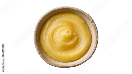 Bilde på lerret Creamy yellow sauce or fruit puree in a rustic ceramic bowl, top view, with a sw
