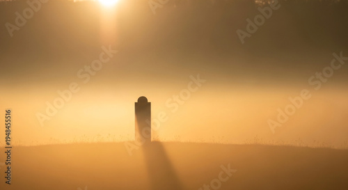 Wallpaper Mural Solitary Monument Silhouette Casting Long Shadow in Golden Misty Sunrise Torontodigital.ca