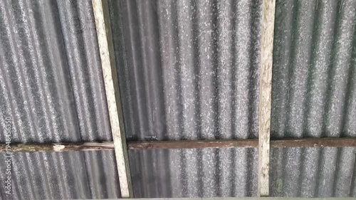 Corrugated metal roof with wooden beams and rusty metal strips