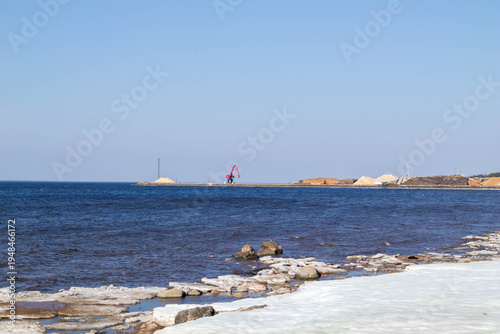 Frozen Sea with Ice and Red Loading Crane – Winter Coastal Industry