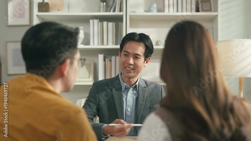 Professional financial advisor presenting investment and savings strategy to couple with tablet analytics, future wealth planning and personal finance consultation concept.	
