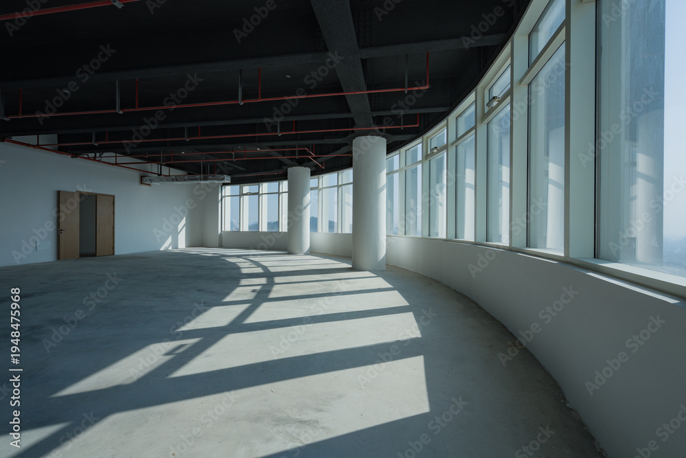 Fototapeta premium Spacious modern office interior with curved floor-to-ceiling windows and natural light