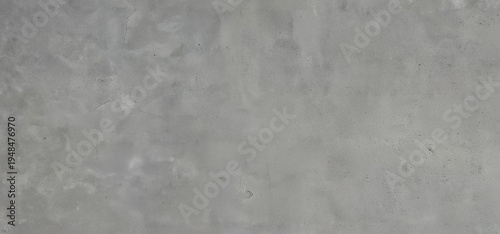 Natural gray concrete wall texture with rough cement surface, subtle cracks and stains, ideal industrial background.