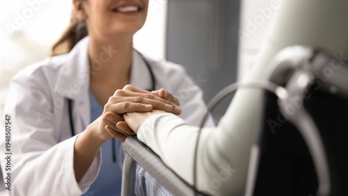 Foto Close up cropped view of smiling doctor holds hands of woman in wheelchair, offe
