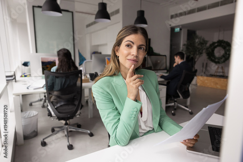 Fotografía Pensive young adult Hispanic businesswoman thinking on paper documents by laptop