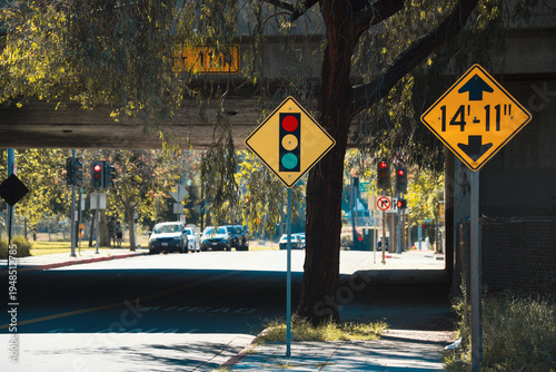 фотографія Yellow traffic signs warn of height restrictions and traffic signals ahead