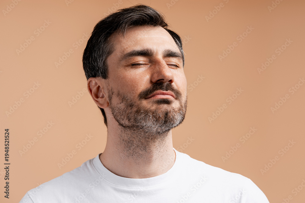 Obraz premium Man with eyes closed, experiencing tranquility and mindfulness
