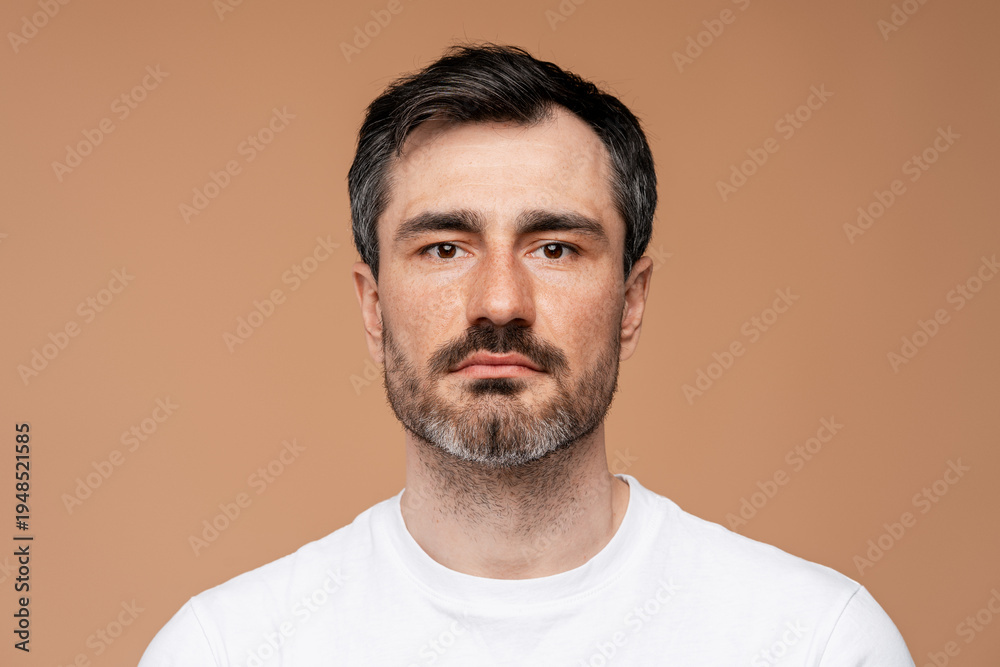 Obraz premium Mature man with beard and neutral expression looking forward, portrait