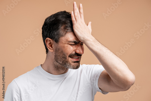 Obraz na płótnie Frustrated man making facepalm gesture, expressing regret and disappointment