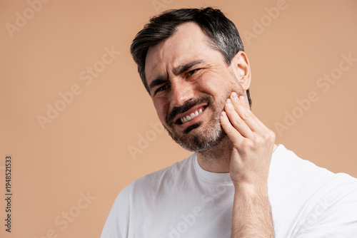 Man feeling severe toothache pain, touching jaw, needing dental care