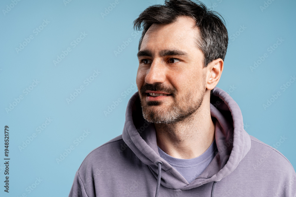 Obraz premium Man in purple hoodie looking away, having an idea or thinking about future