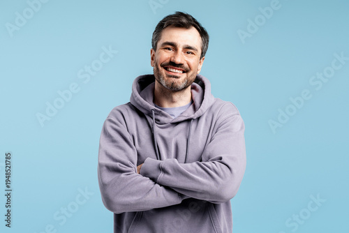Φωτογραφία Happy man in hoodie crossing arms, smiling broadly with confidence