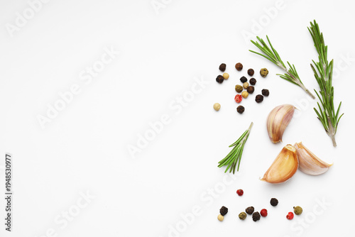 Fresh garlic, peppercorns and rosemary on white background, flat lay. Space for text