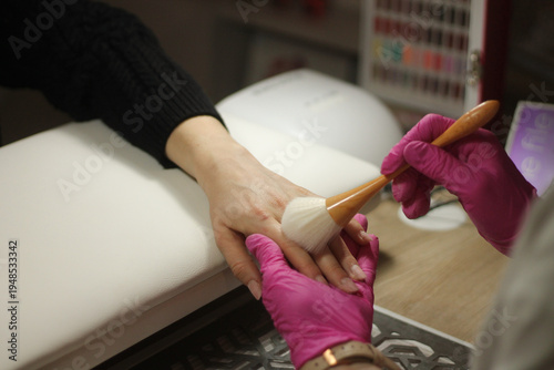 Professional manicure preparation in beauty salon with client hand on manicure pillow